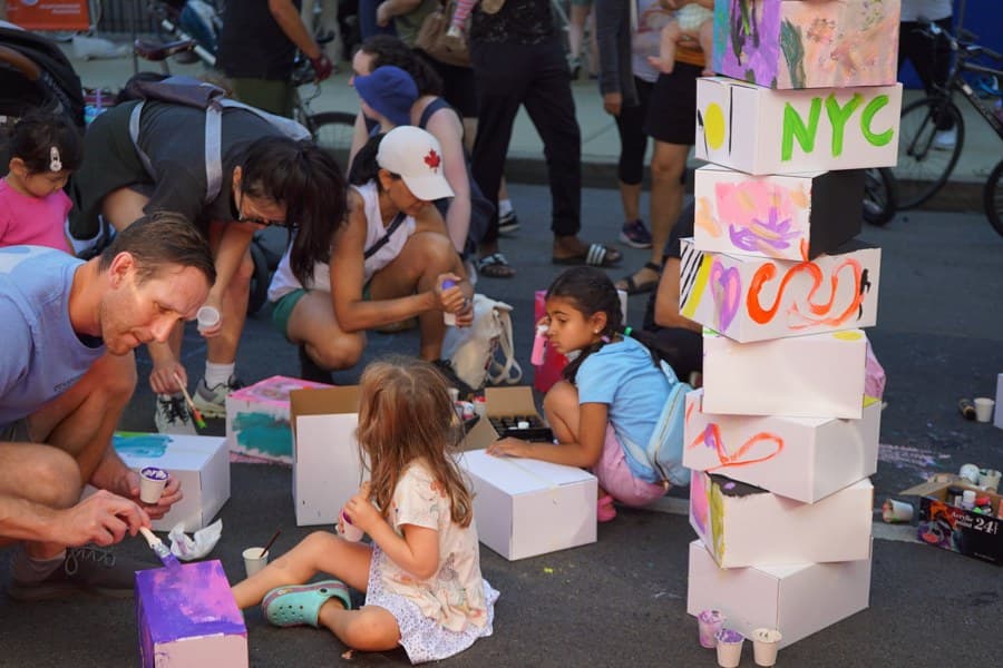 A family painting a colorful NYC box tower together